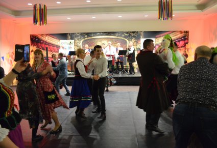 Pary tańczące na sali kameralnej podczas potańcówki w Centrum Folkloru Polskiego. W tle widać scenkę na której stroi Krasocka Kapela