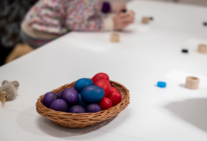 Wydmuszki barwione w koszyczku na stole warsztatowym