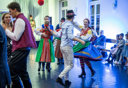 Uczestnicy potańcówki tańczą w parach na Sali Kameralnej Centrum Folkloru Polskiego "Karolin". Część tańczących ubrana jest w stroje wilamowskie.
