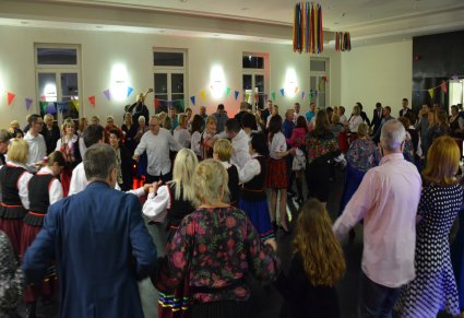 Goście na potańcówce na sali kameralnej w Centrum Folkloru Polskiego. Tańczą na kołach trzymając się za ręce