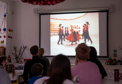 Uczestnicy warsztatu oglądają "Karnawał w Wilamowicach" Zespołu Mazowsze na projektorze na Sali Edukacyjnej Centrum Folkloru Polskiego "Karolin"