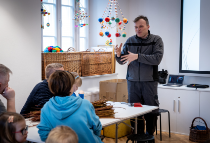 Wojciech Świątkowski, prowadzący warsztat, rozmawia z uczestnikami na Sali Edukacyjnej Centrum Folkloru Polskiego "Karolin"