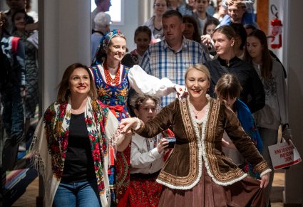 Goście Nocy Muzeów 2024 tańczą poloneza we wnętrzach Centrum Folkloru Polskiego "Karolin"