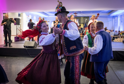 Pary w strojach regionalnych tańczą na Sali Kameralnej Centrum Folkloru Polskiego "Karolin" .