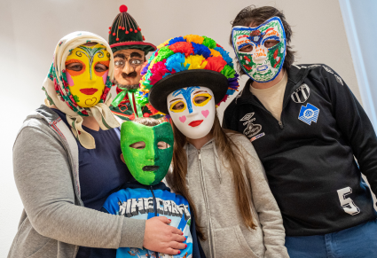 Uczestnicy warsztatu w samodzielnie wykonanych maskach pozują do zdjęcia przy manekinie ubranym w kostium śmiergustnika Zespołu "Mazowsze"