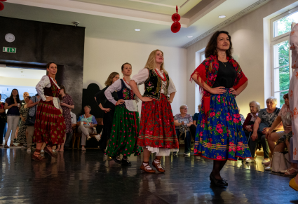 Nauka kroków damskich do tańca góralskiego: goście potańcówki tańczą po obwodzie koła z rękami na biodrach