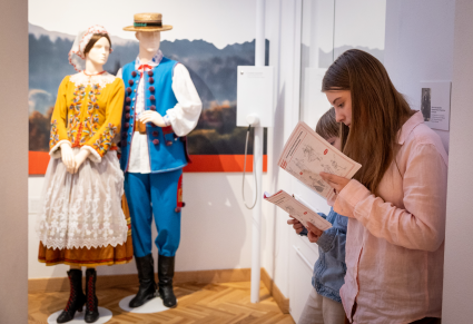 Zwiedzający na wystawie Centrum Folkloru Polskiego "Karolin" wypełniają karty pracy