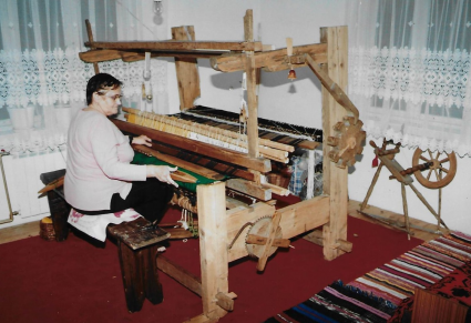 Kobieta siedząca przy warsztacie tkackim
