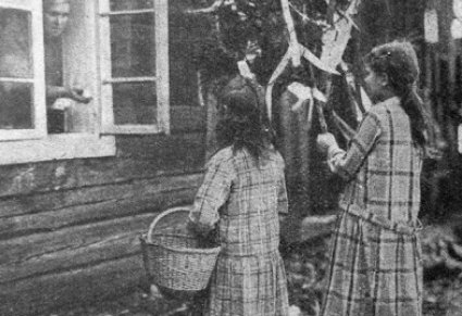 Dziewczynki z goikiem stojące pod oknem drewnianego domu