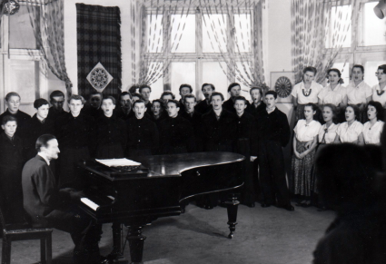 Sala prób, przy fortepianie Tadeusz Sygietyński, po jego lewej stronie ustawiony w rzędach chór Zespołu