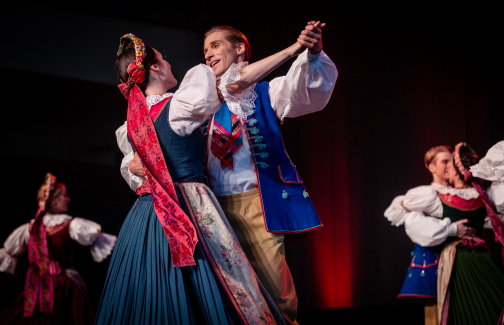 Mazowsze Ensemble couples dancing on stage in costumes from Rozbark
