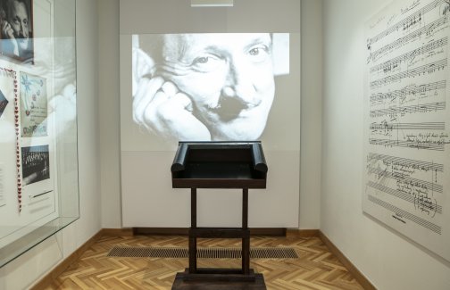 fragment ekspozycji, sala poświęcona Tadeuszowi Sygietyńskiemu, jego pulpit dyrygencki, na ścianie wyświetlany z rzutnika czarno-biały portret Tadeusza