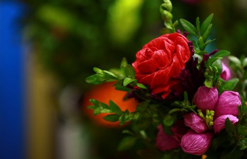 Bukiet kwiatów z bibuły, czerwona róża, inne kwiaty różowe, ozdobione gałązkami bukszpanu