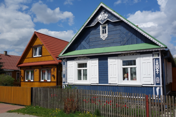 Tradycyjna zabudowa w miejscowości Białowieża, na zdjęciu widoczne dwa drewniane domy zwrócone szczytem do ulicy