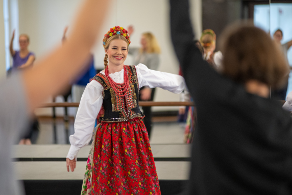 Zdjęcie z warsztatów tanecznych prowadzonych przez artystkę baletu zespołu Mazowsze, ubraną w kostium krakowski