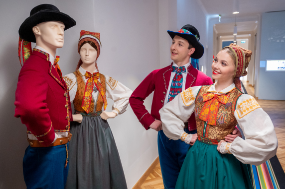 Para artystów zespołu Mazowsze w kostiumach wilamowskich zespołu Mazowsze oglądająca manekiny w takich samych kostiumach na wystawie