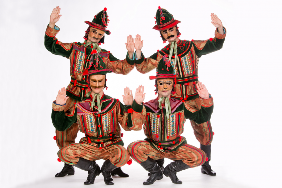 Czterech tancerzy w przebraniach kolorowych pajaców