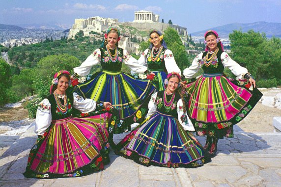 Five female artists from Mazowsze Ensemble in costumes from the Łowicz region pose in front of the Acropolis