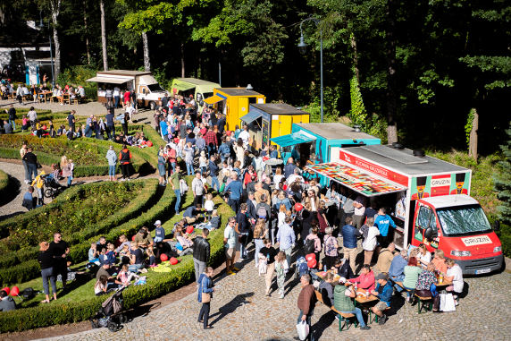 Drone footage of food trucks in the drive outside Karolin Palace, with crowds of people standing around the cars