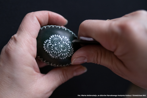 Scratching patterns onto a dyed egg with a knife