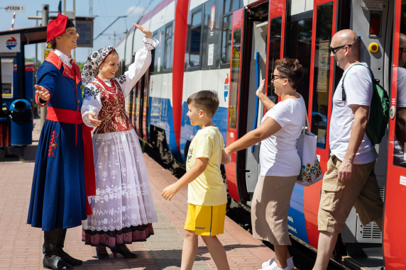 Na peronie stacji WDK para w kostiumie ludowym wilanowskim wita wysiadającą z pociągu rodzinę