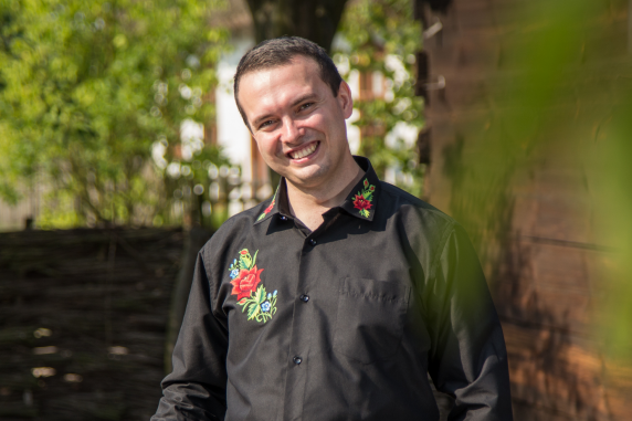 Mateusz Chmielewski w koszuli zdobiona kwiecistym haftem