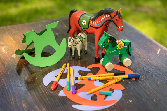 Wooden toys and paper horse-shaped cutouts on a wooden table