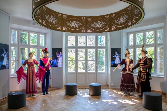 The foyer. Visible are ‘Mazowsze’ Ensemble’s costumes from the Napoleonic Era and those of the Polish nobility, a light fixture with folk art motifs and poufs for visitors