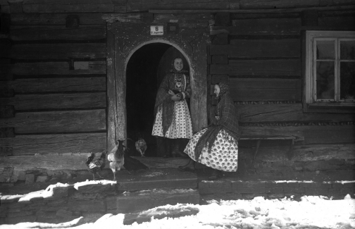 Kobiety z Wilamowic w strojach regionalnych przed domem